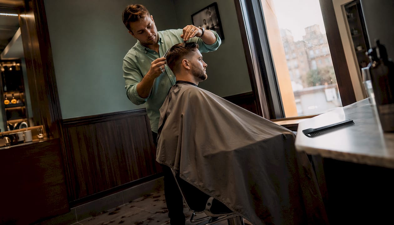 Muž si užíva nový účes v štýlovom barber shope
