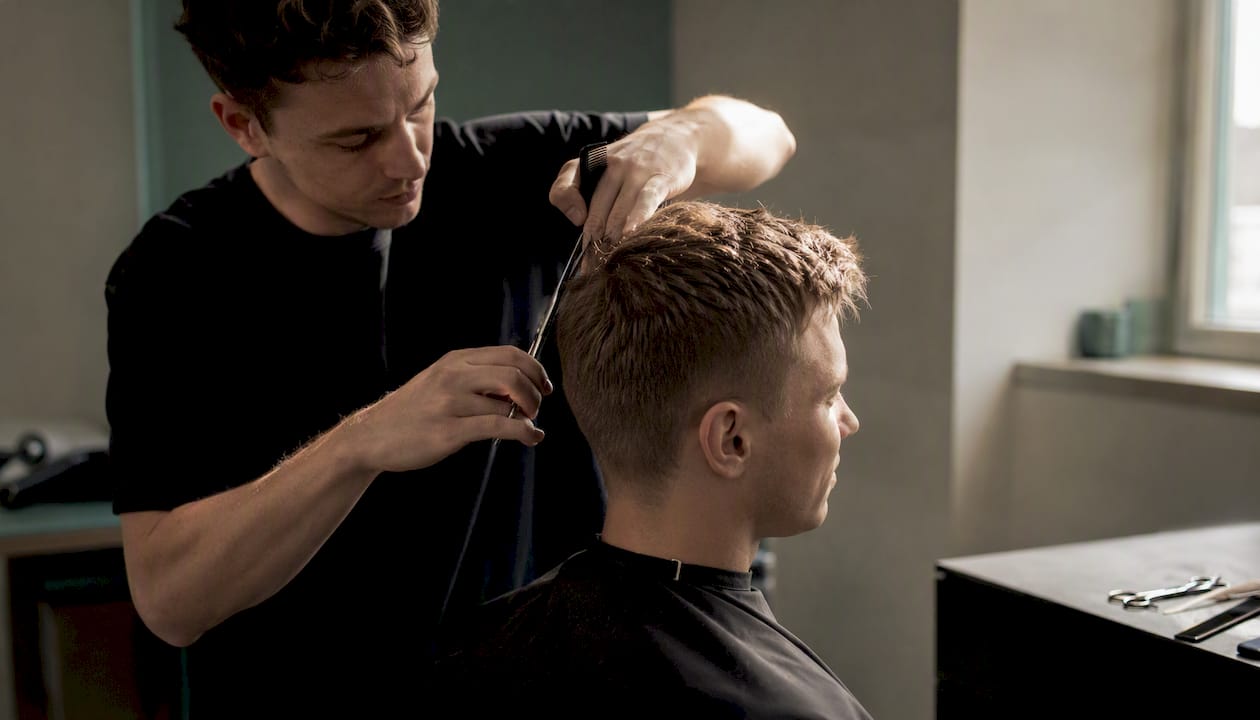 Barber upravuje krátky pánsky účes technikou pre zvýraznenie textúry.