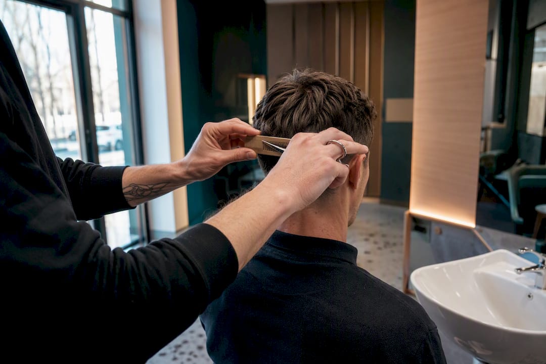 Kaderník strihá vlasy v barbershope bez objednania